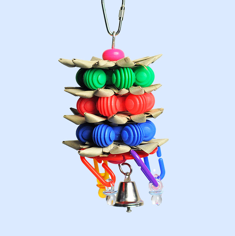 A colorful Palm Star Stacker bird toy from Squawk Shop, featuring shreddable palm leaves, grooved plastic beads, dangling links, and a bell for fun engagement.