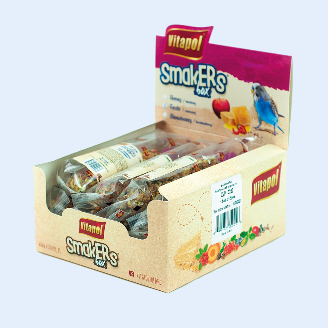 A display box of Vitapol Smakers treat sticks for parakeets, featuring a variety of flavors like honey and fruit. The packaging shows a blue parakeet and vibrant illustrations of the ingredients. Available at Squawk Shop.