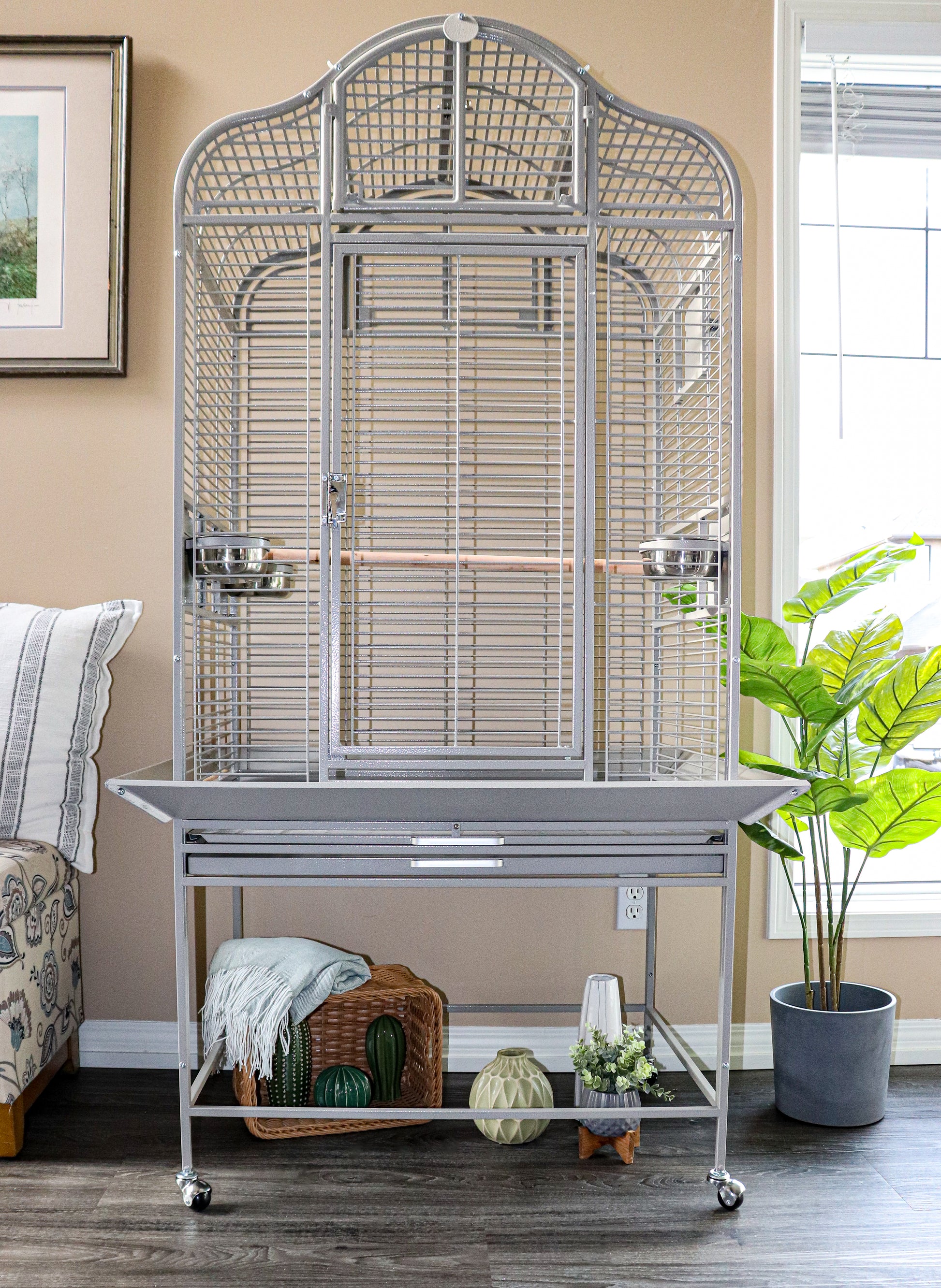 Large white parrot cage in a modern living room with natural light, next to a Java tree stand and cozy seating area — Squawk Shop bird setup inspiration