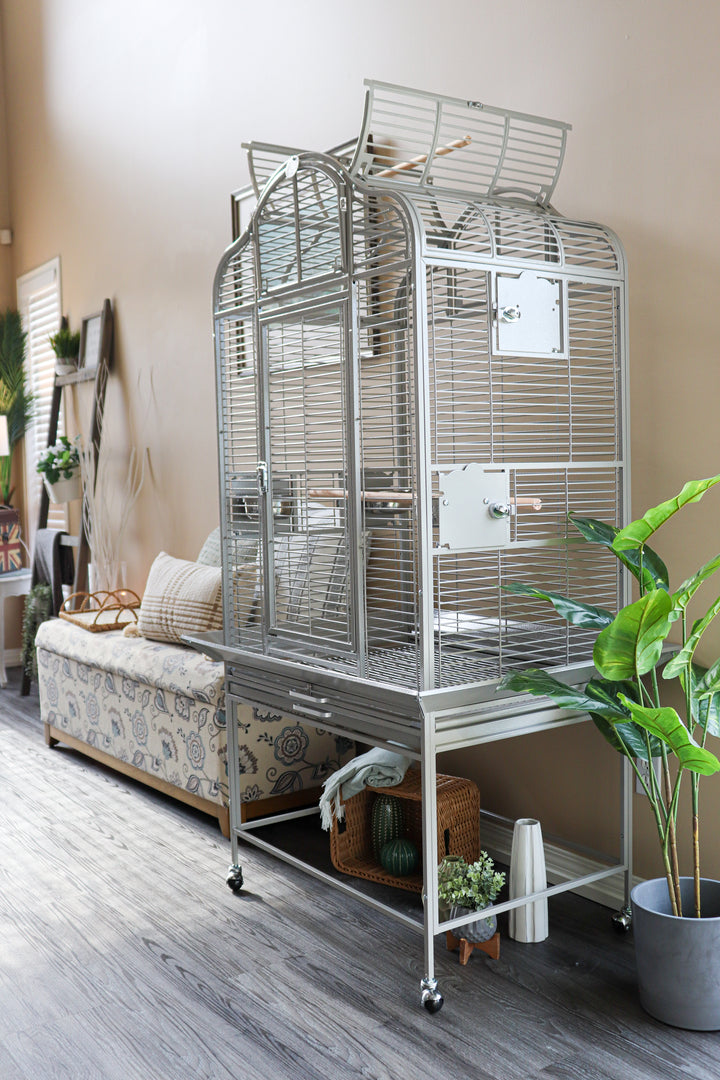 Large white parrot cage in a modern living room with natural light, next to a Java tree stand and cozy seating area — Squawk Shop bird setup inspiration