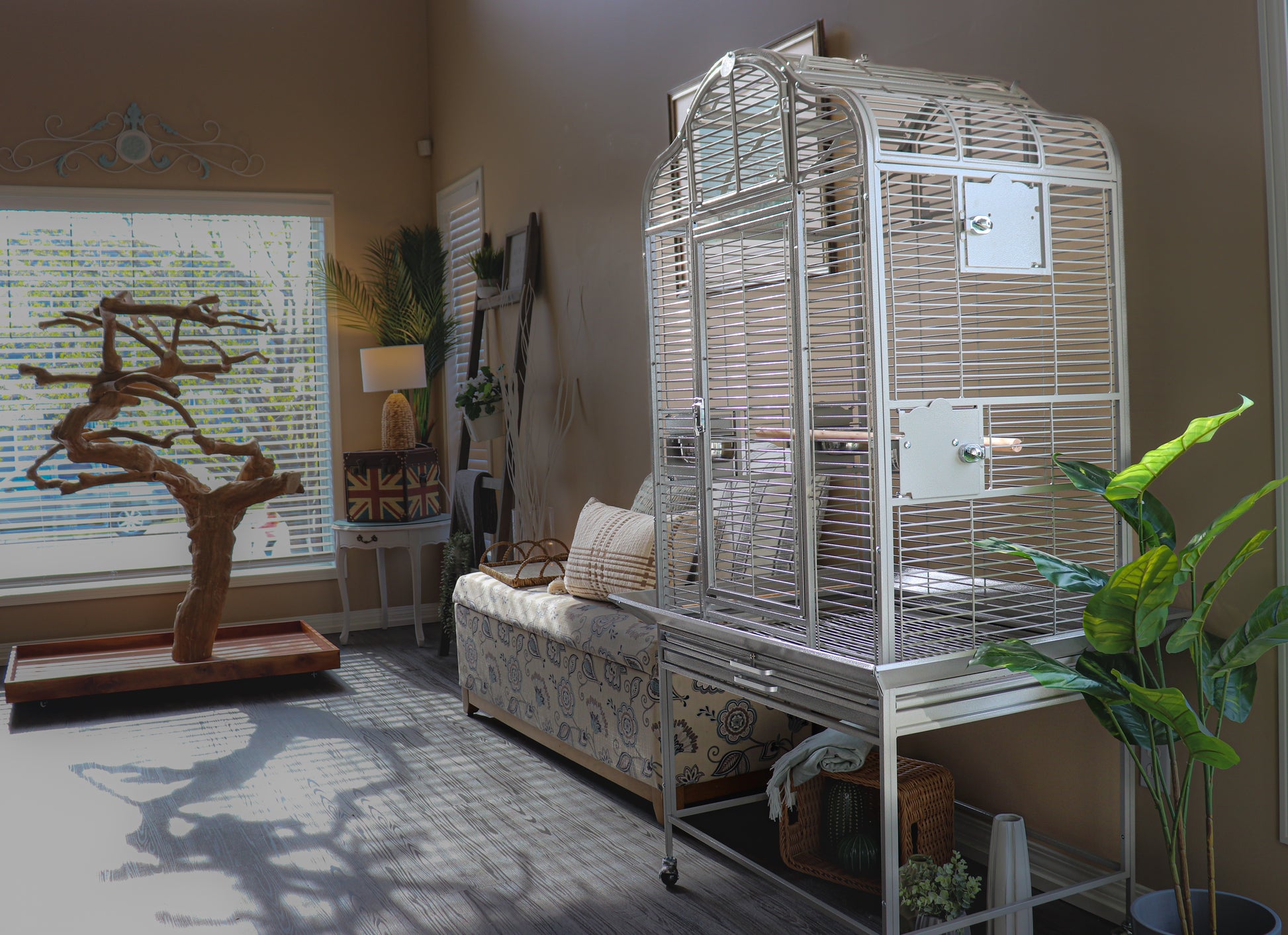 Large white parrot cage in a modern living room with natural light, next to a Java tree stand and cozy seating area — Squawk Shop bird setup inspiration