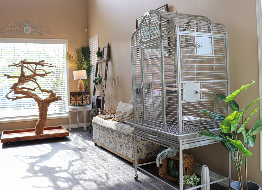 Large birdcage in a living room with a couch and decorative items.