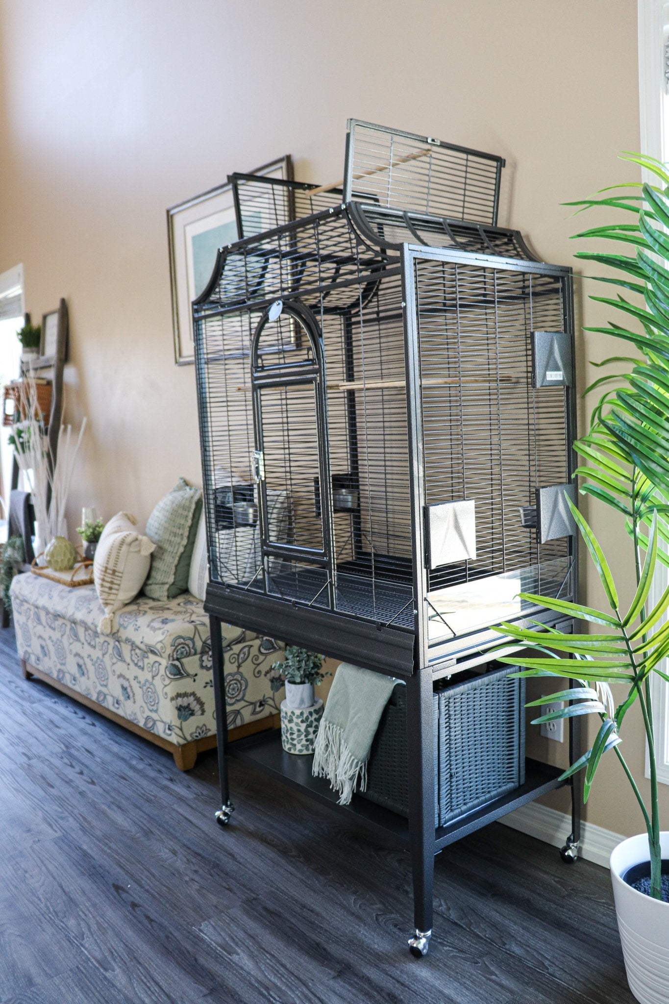 Elegant Flight Bird Cage in black with dome top open placed in a stylish living room setting with natural light, cozy décor, and greenery — Squawk Shop lifestyle display