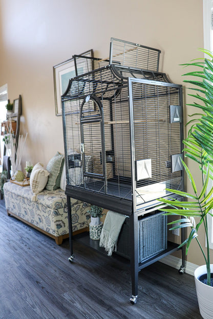 Elegant Flight Bird Cage in black with dome top open placed in a stylish living room setting with natural light, cozy décor, and greenery — Squawk Shop lifestyle display